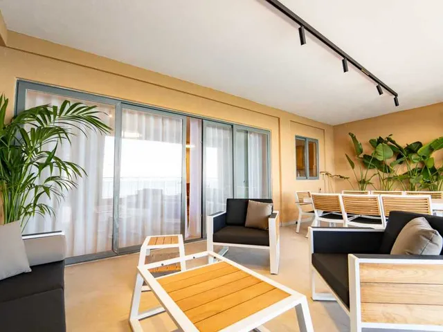 a living room with a couch, chairs, tables and a table with a window