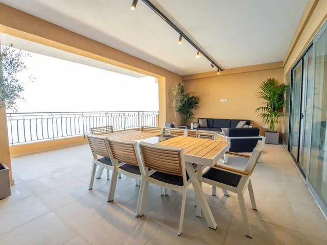a dining room with a large window and a large kitchen