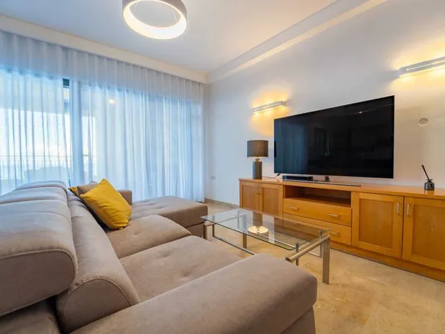 a living room with a couch, television, and coffee table