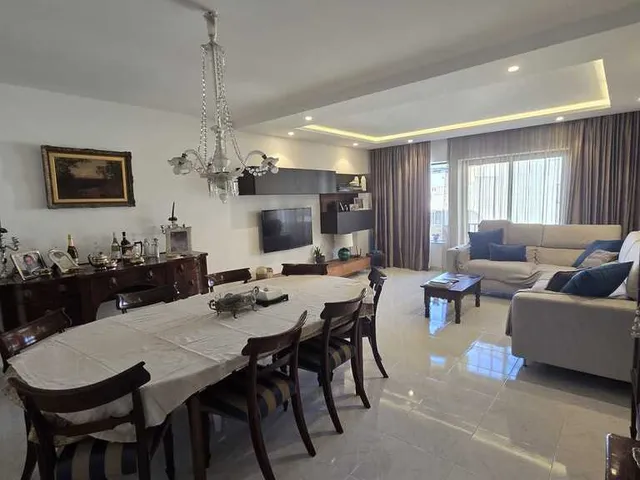 a living room with a couch, table, chairs and a television