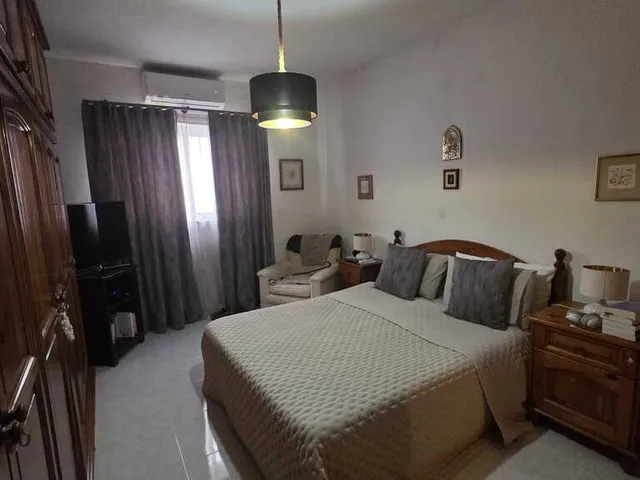 a bedroom with a bed, a dresser, and a television