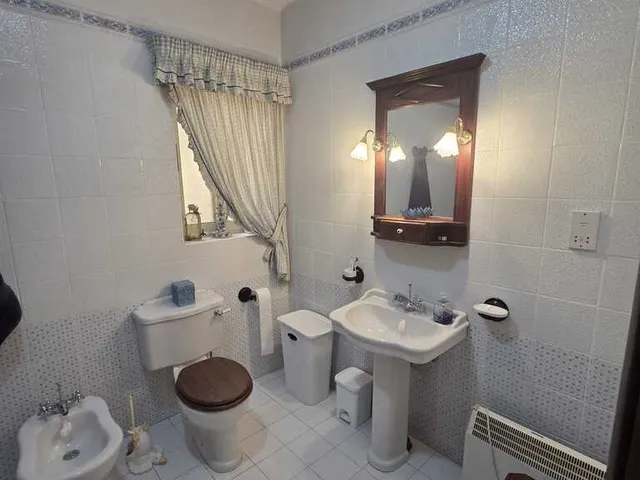 a bathroom with a toilet, sink, mirror and a bath tub