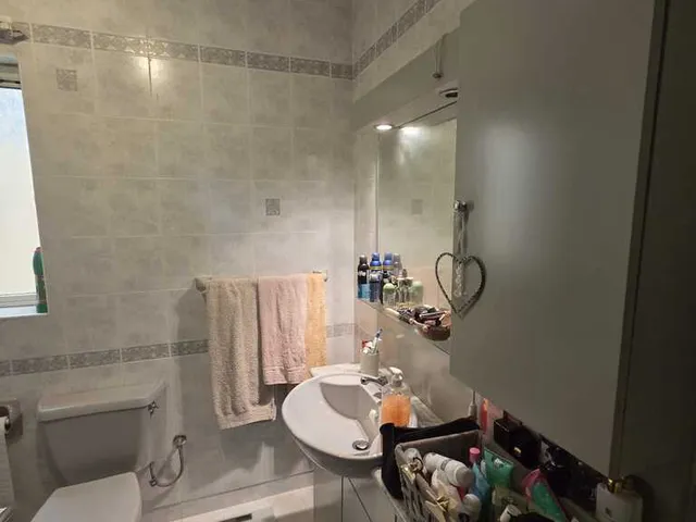 a bathroom with a sink, mirror, and towels