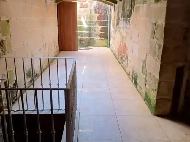 a doorway leading to a small room with a stone wall