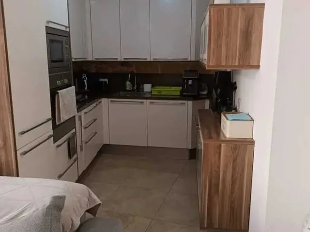 a kitchen with a stove, sink, and refrigerator