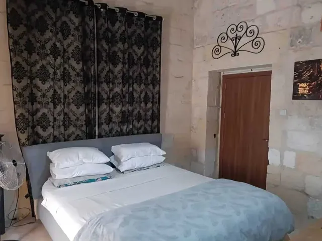 a bed with a white bedspread and a blue wall