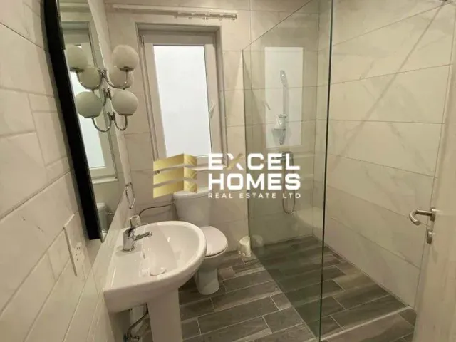 a bathroom with a toilet, sink, and mirror