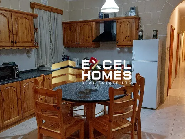 a kitchen with a table and chairs and a refrigerator